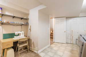 Interior space with baseboards, laundry area, a textured ceiling, and washer and clothes dryer