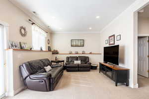 Living area featuring light colored carpet, recessed lighting, baseboards, and crown molding