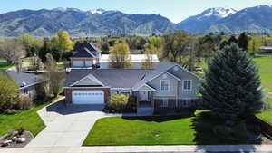 View of front of home featuring a garage, a mountain view, and brick siding