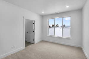 Unfurnished room featuring carpet floors, baseboards, and visible vents