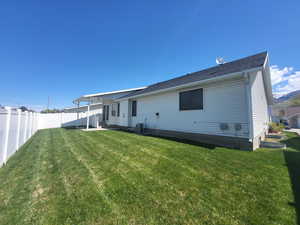 Rear view of property featuring fence private yard, central AC unit, and a yard
