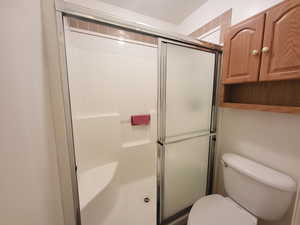 Bathroom with toilet and a stall shower