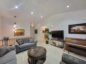 Carpeted living room with recessed lighting and lofted ceiling