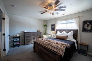 Bedroom with baseboards, ceiling fan, carpet flooring, and visible vents