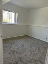Carpeted empty room featuring baseboards