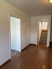Empty room with baseboards, stairs, and wood finished floors