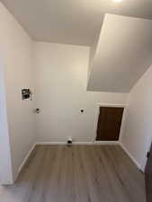 Clothes washing area with light wood-style floors, washer hookup, baseboards, and electric dryer hookup