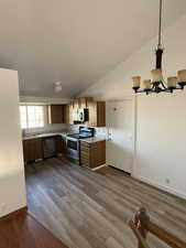 Kitchen featuring an inviting chandelier, light countertops, a sink, dark wood finished floors, and stainless steel appliances
