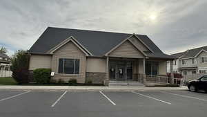 CLUB HOUSE: Exterior space with uncovered parking, stone siding, and covered porch