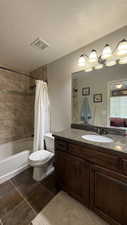 Full bath with vanity, tile patterned floors, toilet, visible vents, and shower / tub combo with curtain