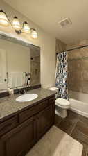 Full bathroom featuring a textured ceiling, visible vents, toilet, shower / bath combination with curtain, and vanity