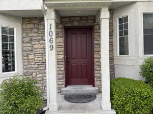 View of exterior entry featuring stone and stucco siding