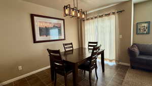 Dining area featuring an inviting chandelier, a textured ceiling, and baseboards