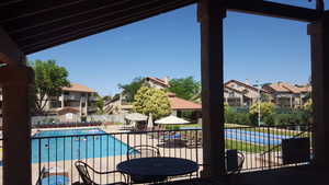 Pool with a patio, fence, and a residential view
