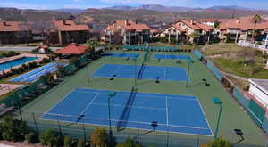 View of sport court featuring fence, a mountain view, and a residential view
