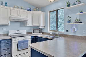 Kitchen with open shelves, stainless steel microwave, under cabinet range hood, white range with electric stovetop, and a sink