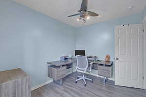Office space with baseboards, a ceiling fan, and wood finished floors