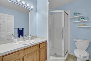 Bathroom with vanity, toilet, tile patterned floors, a textured ceiling, and a shower stall