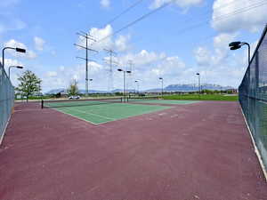 View of sport court with fence and a mountain view