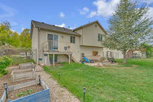 Rear view of house featuring a garden, a lawn, a patio area, fence, and stairs