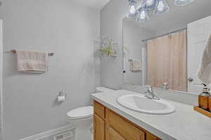 Bathroom featuring a notable chandelier, vanity, toilet, a textured ceiling, and visible vents