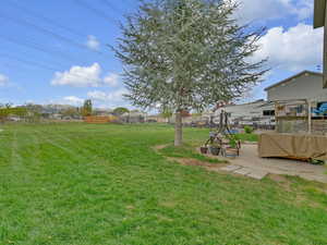 View of yard featuring fence and a patio area