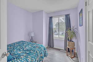 Bedroom featuring a textured ceiling, baseboards, visible vents, and light wood-type flooring