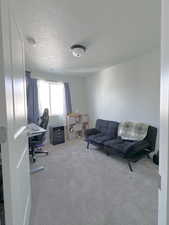 Carpeted home office featuring a textured ceiling and visible vents
