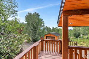Wooden deck with an outdoor structure and a garage