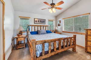 Bedroom featuring carpet flooring, visible vents, multiple windows, and lofted ceiling