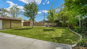 View of yard featuring a storage unit, an outdoor structure, a fenced backyard, and a patio