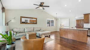 Living room with a ceiling fan, dark wood-style flooring, vaulted ceiling, baseboards, and recessed lighting