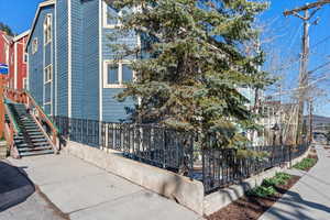 View of property exterior featuring fence and stairway