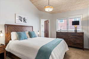 Bedroom featuring carpet flooring and lofted ceiling