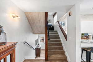 Stairs with baseboards and wood finished floors