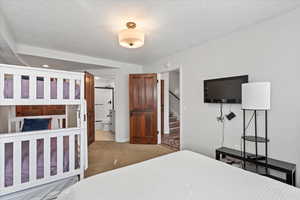 Carpeted bedroom featuring ensuite bathroom
