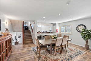 Dining room with stairs, recessed lighting, baseboards, wood finished floors, and visible vents