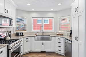 Kitchen with a sink, white cabinets, stainless steel appliances, and recessed lighting