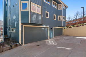 Back of property with a garage and driveway