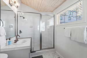 Bathroom featuring vanity, marble finish floor, baseboards, wooden ceiling, and a stall shower
