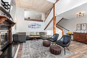Living room with wood ceiling, a fireplace, stairs, and wood finished floors