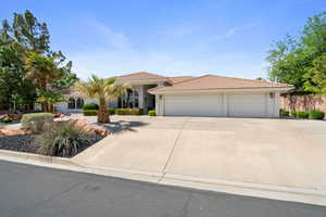 View of front of house featuring a garage, stucco siding, a tiled roof, and driveway