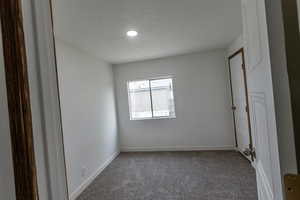 Carpeted spare room featuring baseboards and recessed lighting