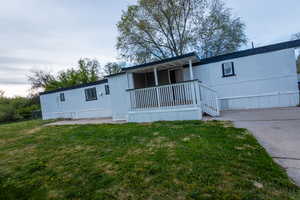 View of front of property featuring a porch and a front yard