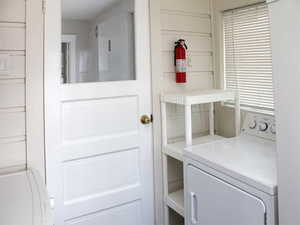Laundry area featuring washer / dryer and laundry area of White Door unit 2 with a 2nd outside entrance leading to the backyard.