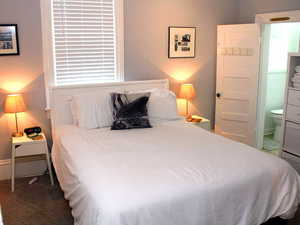 Carpeted bedroom with ensuite bathroom in 1-bed Red Door unit.  Unit comes with everything you see in the photo
