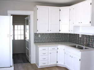 Newly Remodeled kitchen featuring white cabinets, freestanding refrigerator, and a brand new sink in White door unit 2.