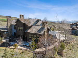 Back of property with a chimney and a patio area