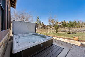 Exterior space with a hot tub and a yard