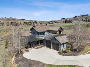Exterior space featuring covered porch, an attached garage, concrete driveway, and metal roof